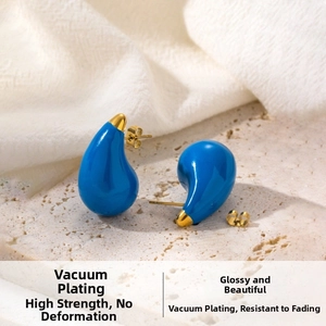 Detail of blue enamel teardrop earrings with gold plating on natural travertine stone