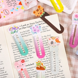 Cute animal and floral bookmark rulers including tiger and cat patterns on an open book