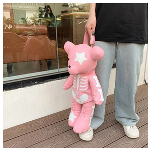 Detailed view of punk style pink bear bag with white star patches and bone pattern