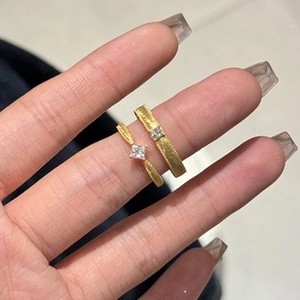 Detailed macro of golden bamboo style rings featuring square gemstones and brushed metal finish