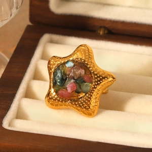 Star-shaped stainless steel ring with natural colorful stone inlay in a wooden jewelry box