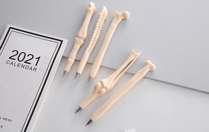 Flat lay of five creative bone-shaped ballpoint pens with realistic skeletal details