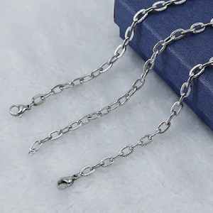 Detail shot of a silver embossed chain with a secure lobster clasp on a gift box
