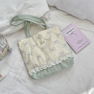 Detail of lace trim and purple bow print on a floral canvas commuter tote bag