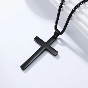 Detail of a matte black stainless steel cross pendant with a matching box chain for men