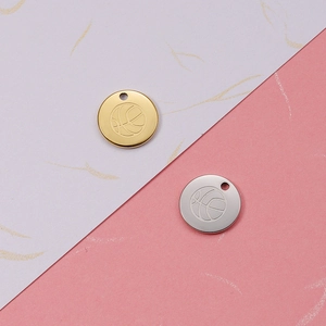 Detailed macro view of 18K gold and silver basketball pendants with etched patterns