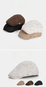 Detailed view of the vintage beret hat featuring a gold letter G metal hardware emblem