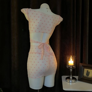 Sexy pink sheer mesh mini dress with bow print and lace-up open back on mannequin