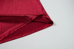 Detailed close-up of wine red velvet fabric hem showing high-quality stitching and texture