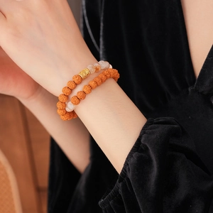 Close-up of double-layer bodhi seed bracelet with golden engraved bead and white stones