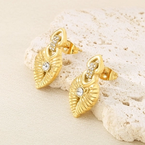 French style gold leaf earrings with crystals on a beige stone minimalist display