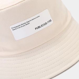 Minimalist cream white cotton bucket hat with letter patch and twill texture detail