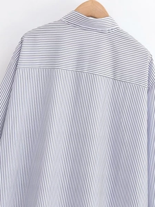 Detail of blue striped poplin shirt showing neckline and back yoke on wooden hanger