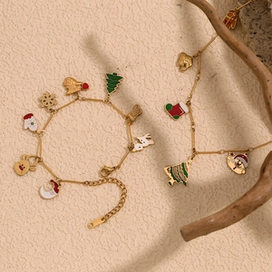Détail d'un bracelet de Noël doré orné de breloques émaillées colorées pour les fêtes