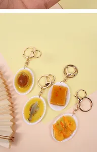 Dettaglio di portachiavi alimentari realistici con frutti di mare su piccoli piatti bianchi