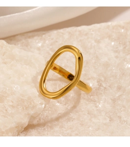 Macro shot of polished gold oval ring on crystal rock and silk background with soft lighting