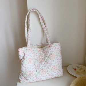 Macro detail of floral quilted tote bag with pink flower pattern and woven brand label