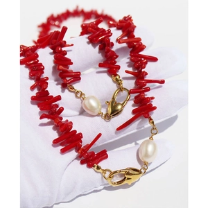 Handmade necklace set with red branch corals and white freshwater pearls on white glove