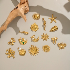 Artistic layout of 18K gold plated nautical pendants like octopus and starfish on driftwood