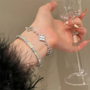Elegant silver flower clover beaded bracelet set with sparkling zircon on a female wrist