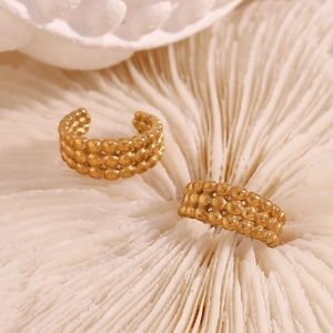 Vue macro de boucles d'oreilles plaquées or 18 carats avec trois rangées de perles
