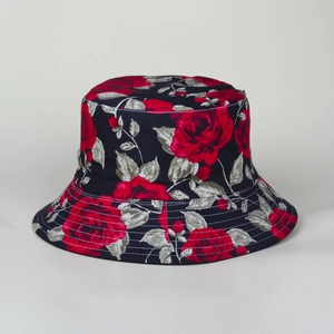 Close-up of red rose floral print and fine stitching on a navy blue cotton bucket hat