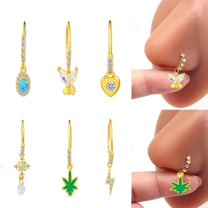 Detailed close-up of golden nose hoops with diverse blue gemstone and butterfly pendants