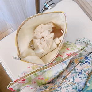 Detail view of floral cotton toiletry bags with simple wish label and metal zipper