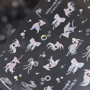 Holographic gold foil nail art stickers with butterfly and fish designs on black background