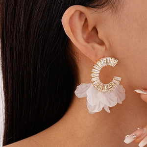 Detailed view of oversized C-shape earrings with zircon studs and delicate white petals