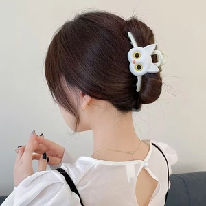 White 3D cat hair claw clip shown on back of head for elegant minimalist hairstyling