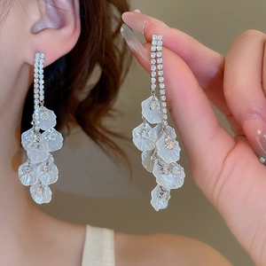 Détail de boucles d'oreilles pampilles plaquées or 18k avec zircon et pétales blancs
