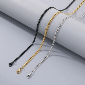 Three curb chains in black gold and silver draped over a grey cylinder stand