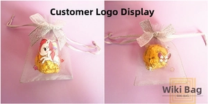 Detail of purple organza drawstring gift bag with silver ribbon bow and unicorn stickers