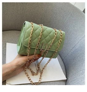 Close-up of light green quilted shoulder bag with gold Y-lock and chain strap