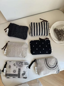 Flat lay of multiple canvas coin purses in denim, stripes, and paisley patterns