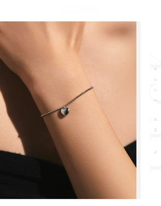 Detailed view of a silver heart charm bead bracelet on a model wrist for daily wear