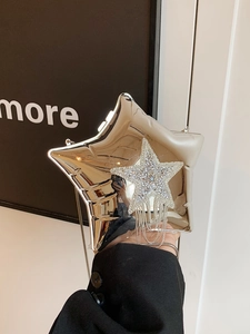Detail of silver star-shaped clutch with rhinestone star and metallic fringe