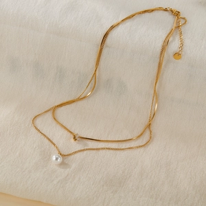 Double layered gold titanium steel necklace featuring a pearl pendant and zircon crystal