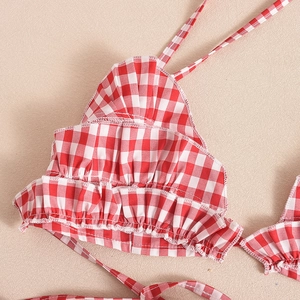Detailed view of red and white gingham fabric with ruffled edges and fine woven texture