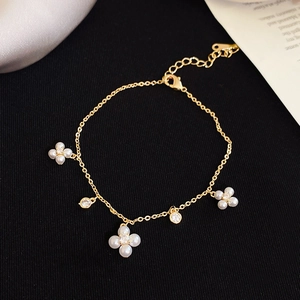 Detailed view of elegant gold floral bracelet with white pearls and sparkling zircons