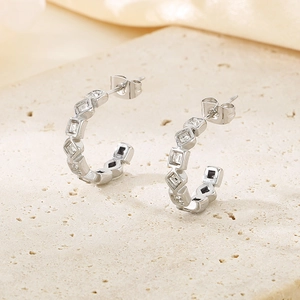 Vue détaillée des boucles d'oreilles C argentées avec pierres carrées sur socle en pierre