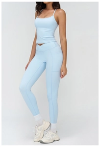 Detail of light blue high waist yoga pants with crossover waistband and side pockets