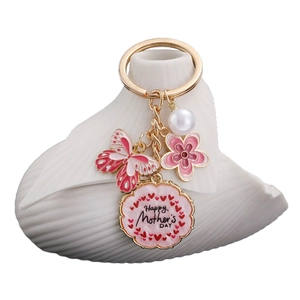 Pink butterfly and flower Happy Mother's Day keychain with pearls on a white shell plate