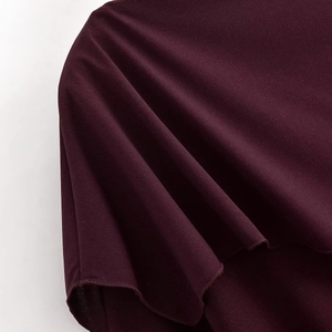 Close-up of wine red draped knit fabric texture with smooth weave and detailed folds