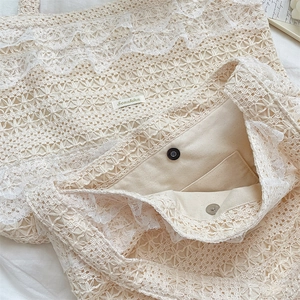 Close-up of lace tote bag interior showing canvas lining and silver magnetic buckle