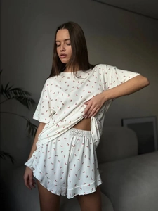 Detail of soft ribbed knit pajama set featuring delicate pink floral prints and ruffles