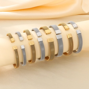 Dettaglio dei bracciali rigidi a rete intrecciata in oro e argento su supporto