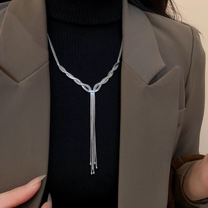 Close-up of a silver tassel necklace with multi-layer snake chains on a black sweater