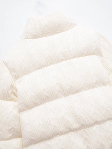 Close-up of white knitted jacket with quilted pattern and thick insulated texture
